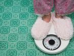 A woman stands on a scale; rapid weight loss can cause health problems.