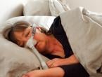 Older woman asleep in bed with a CPAP mask on