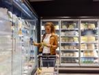 Woman shopping in frozen food section of supermarket