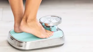 Woman weighing herself on  scale