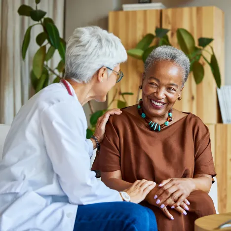Doctor-discussing-with-senior-woman-at-appointment