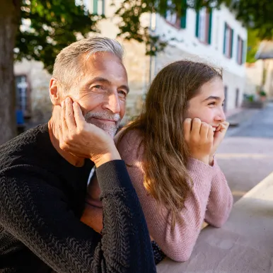grandfather-and-granddaughter-leaning-on-garden-table